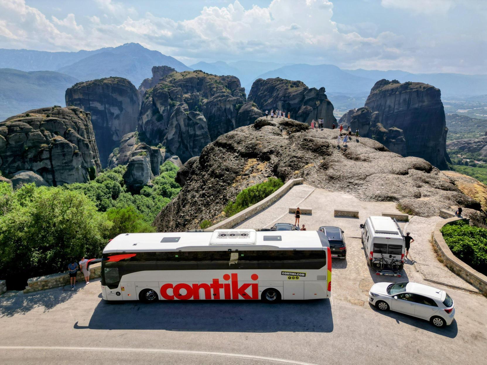 Contiki coach parked with amazing view of rocks behind